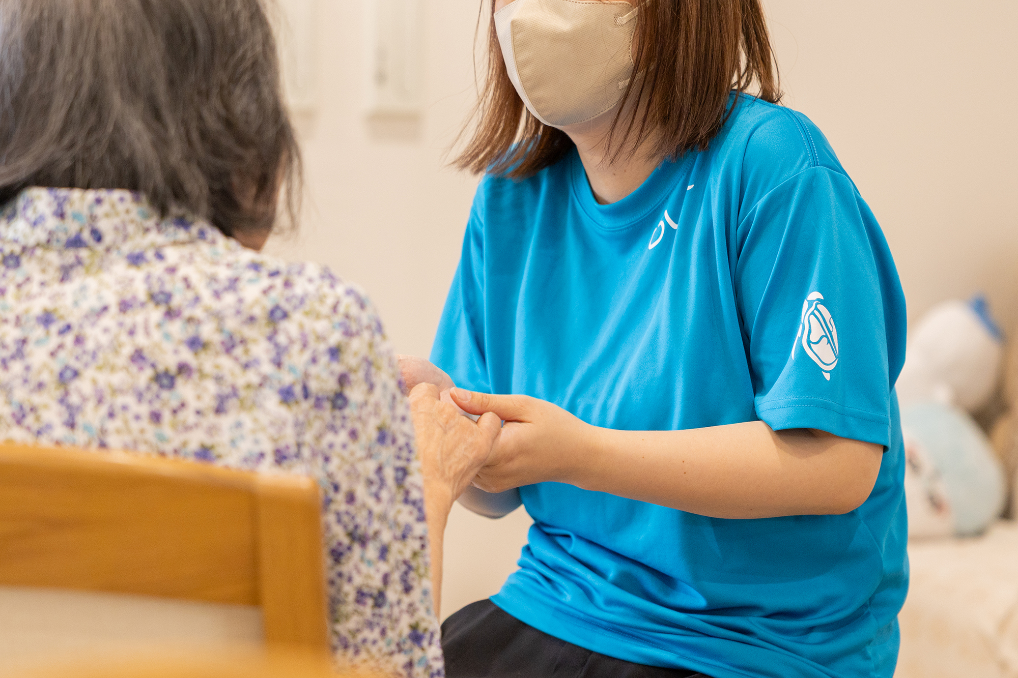 送迎車から降りる利用者に寄り添うスタッフ